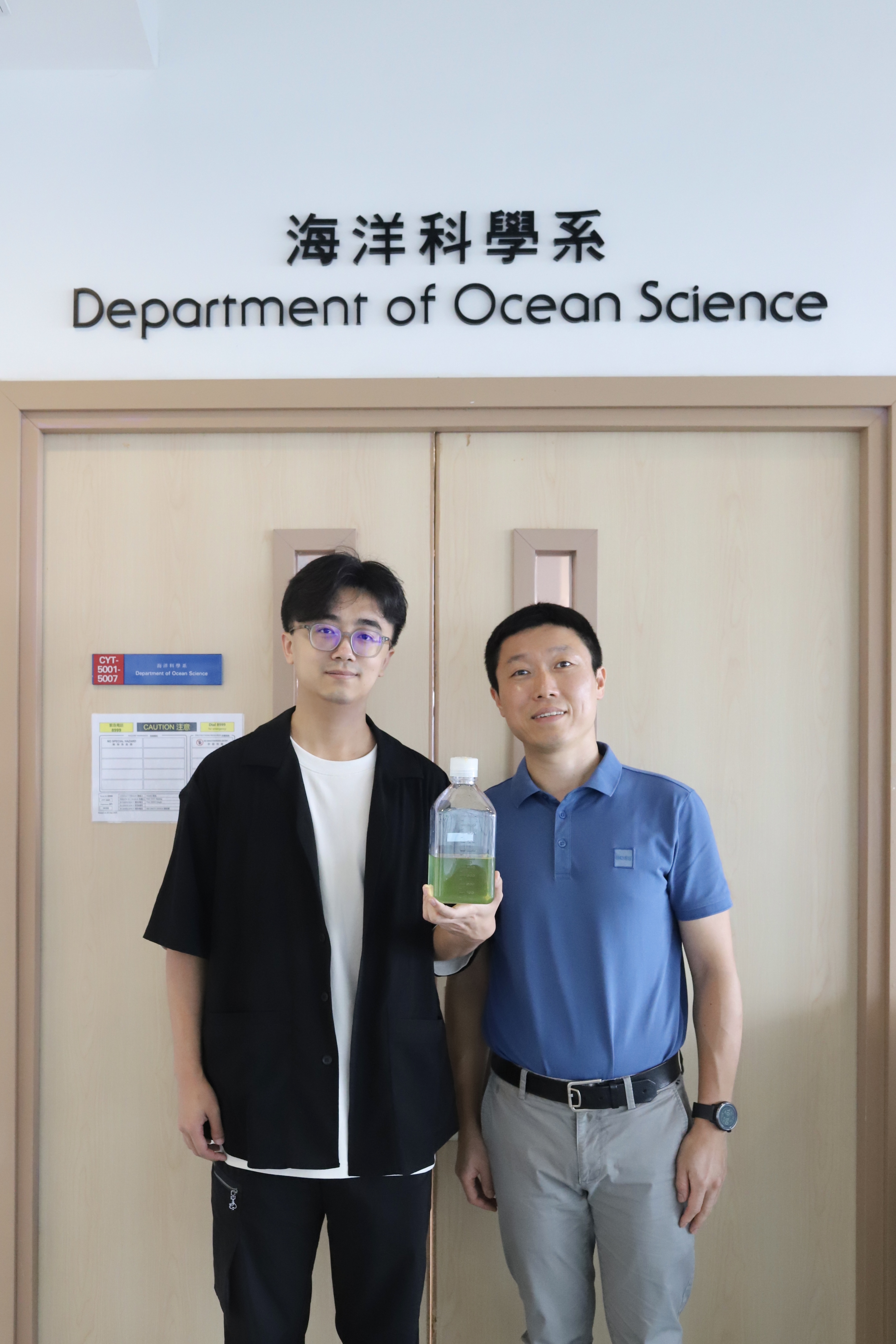 Prof. ZENG Qinglu(right) and one of the research paper author Mr LI Haofu (left), PhD student in Department of Ocean Science, showing the sample of Prochlorococcus MED4 culture.